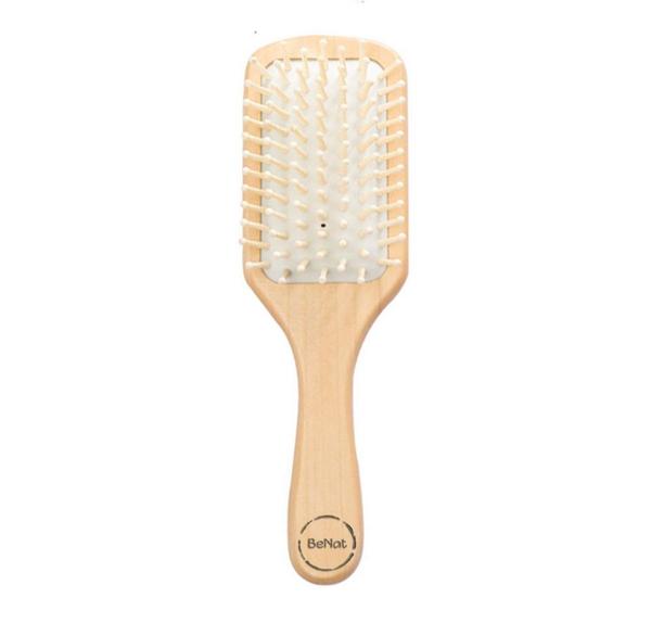 Natural wooden detangling hair brush by Jade Chrysippus, designed for gentle hair care in the bathroom.