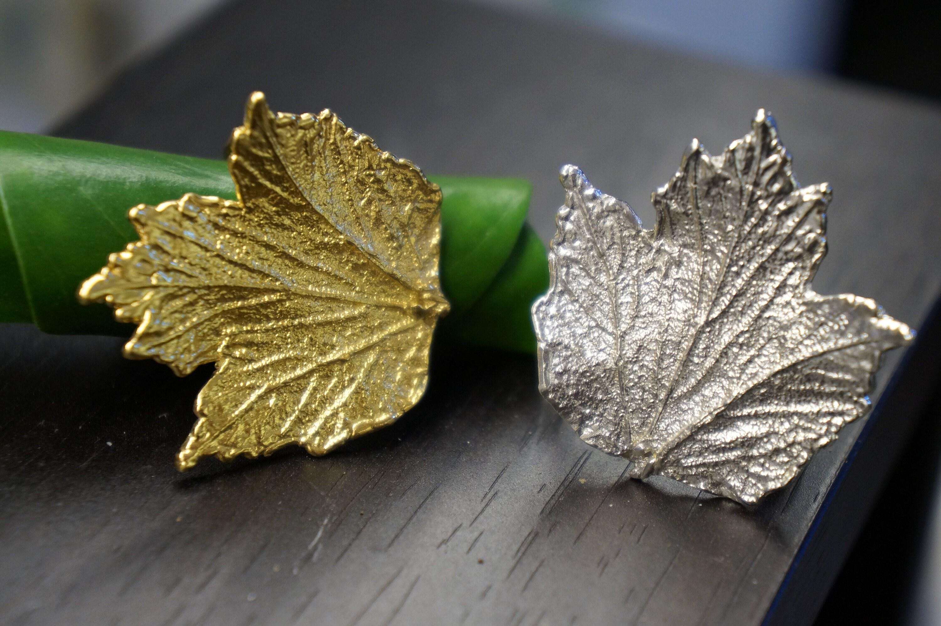 Adjustable gold-plated brass Bourbon Rose Leaf ring from Beige Briseis, featuring detailed floral leaf design on a jewelry and watch image.