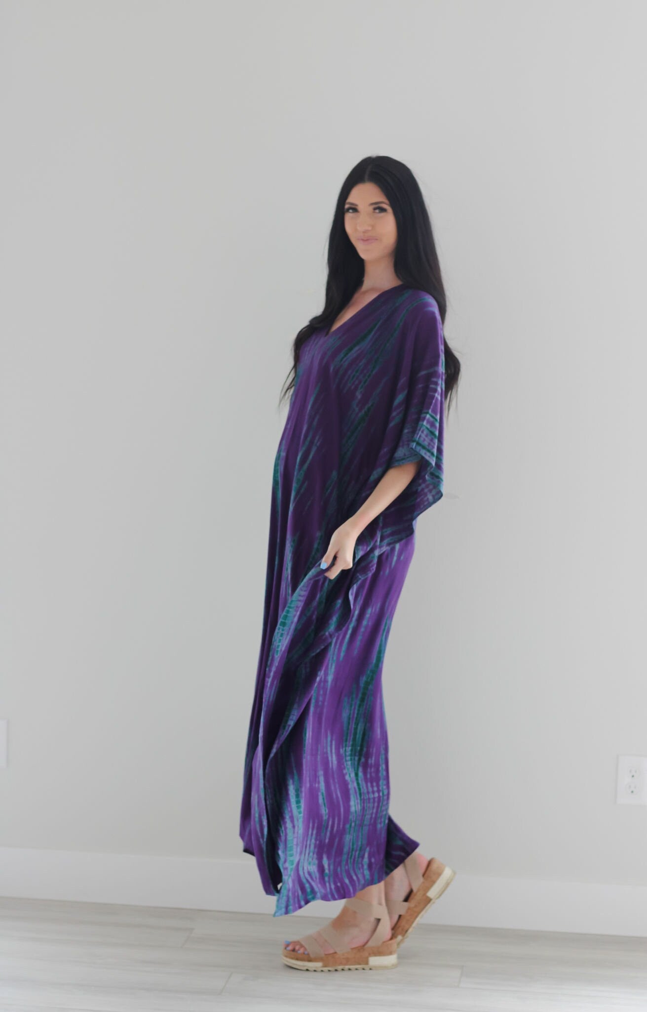 Purple tie-dyed maxi kaftan dress by Erin Pontus, flowing fabric with vibrant purple and blue patterns, perfect for elegant occasions.