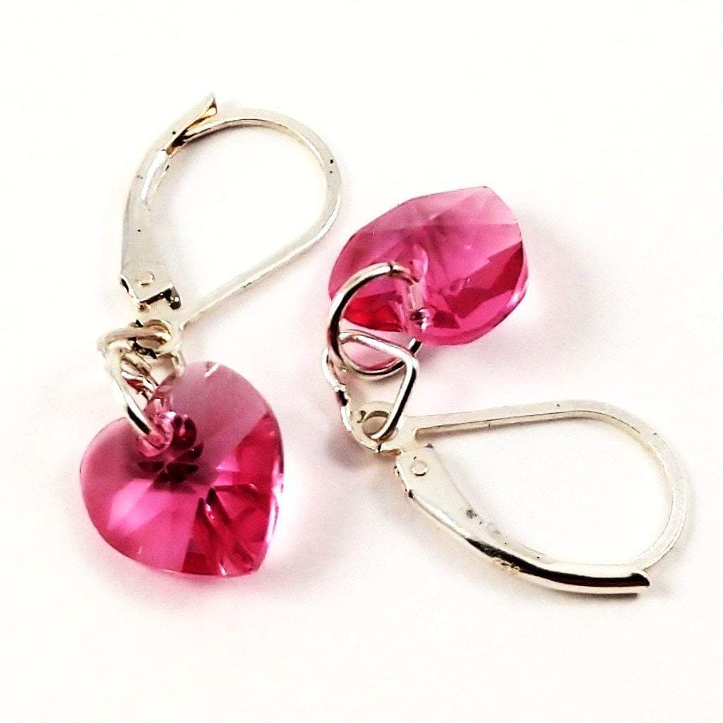 Sterling silver pink crystal heart earrings by Blue Crius, featuring delicate heart-shaped pendants with sparkling pink crystals.