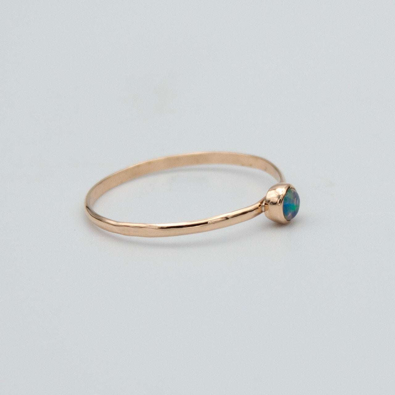 Dainty Ethiopian Opal bezel ring in 14k gold-filled jewelry, featuring a smooth oval opal gemstone setting.