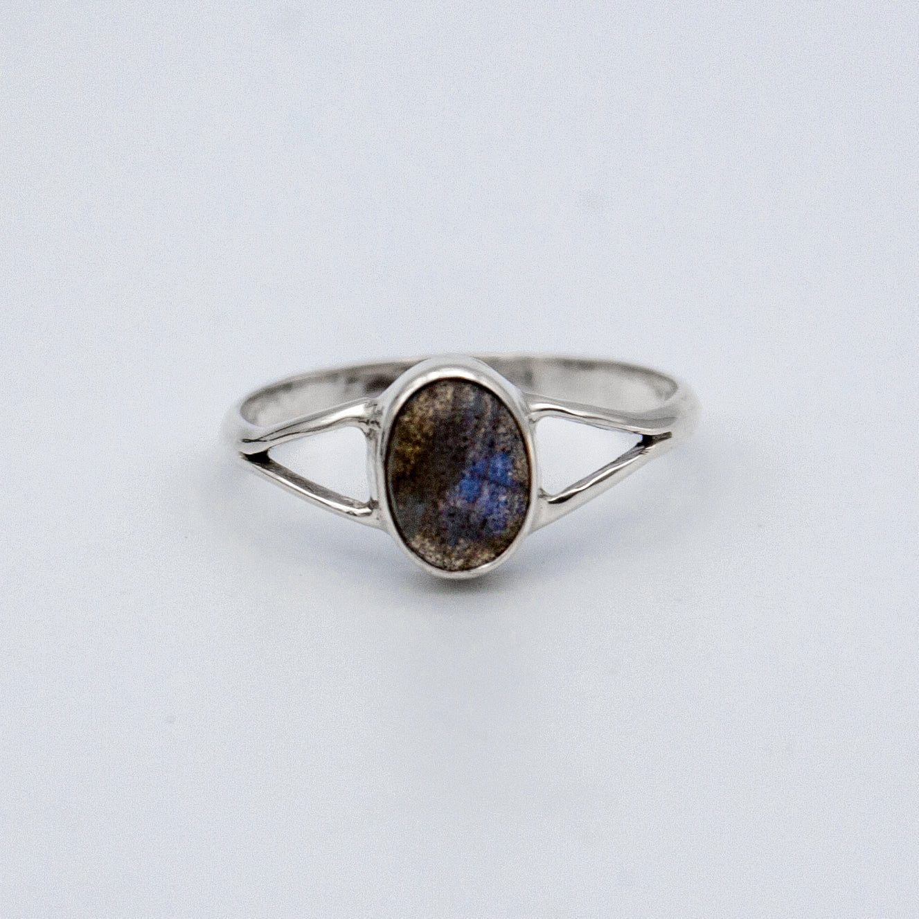 Oval Labradorite bezel split shank sterling silver ring from Grey Clymene, showcasing a shimmering labradorite gemstone and intricate band design.