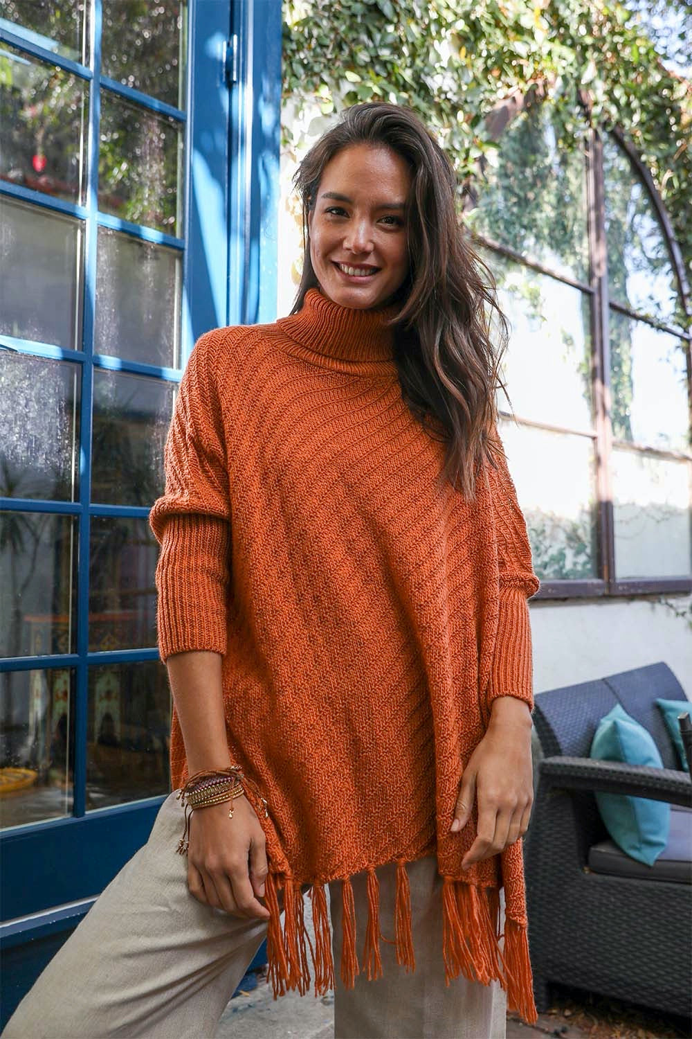 Periwinkle Aether sweater weather roll-neck poncho with turtleneck sleeves and frayed knit edges, cozy and stylish accessory.
