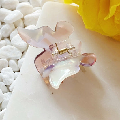 Fuchsia Hercules butterfly hair claw with decorative gold accents, designed to hold hair securely and add a stylish touch.