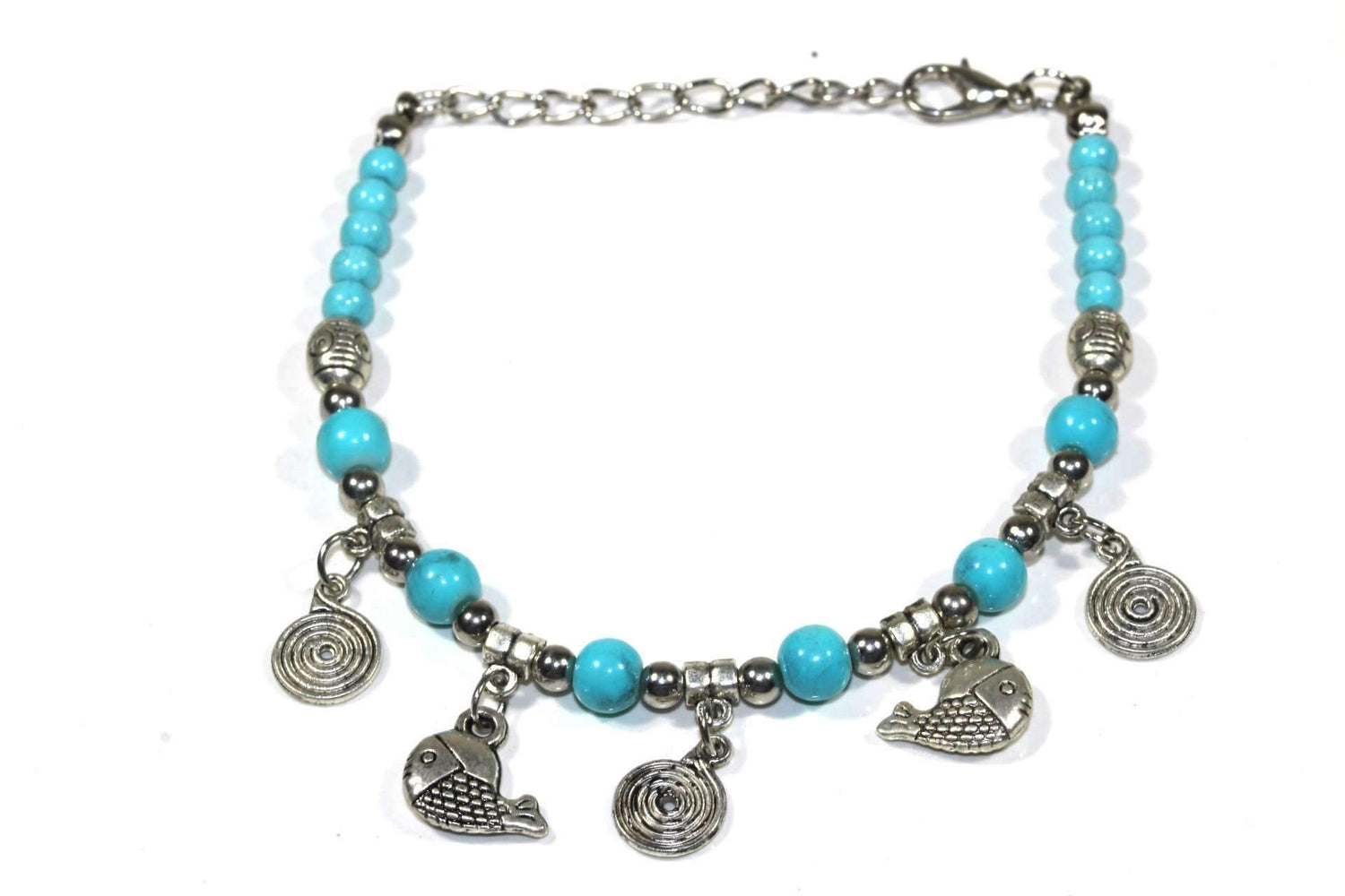Silver Hestia bracelet featuring spirals and fish charms, showcasing intricate metalwork and detailed charm designs.