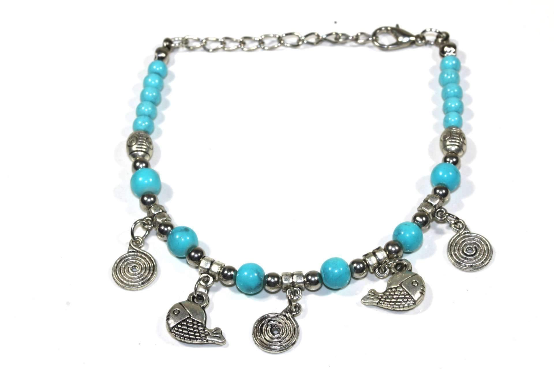 Silver Hestia bracelet featuring spirals and fish charms, showcasing intricate metalwork and detailed charm designs.