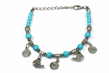 Silver Hestia spirals and fish charm bracelet with detailed metal charms on a delicate chain.