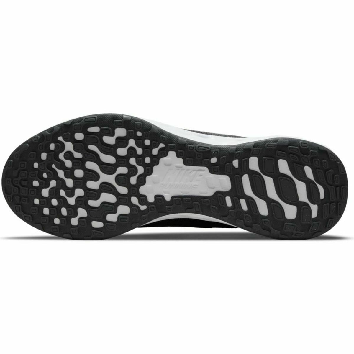 Grey Nike Revolution 6 running shoes for adults, sports footwear with supportive design, displayed in a natural outdoor setting.