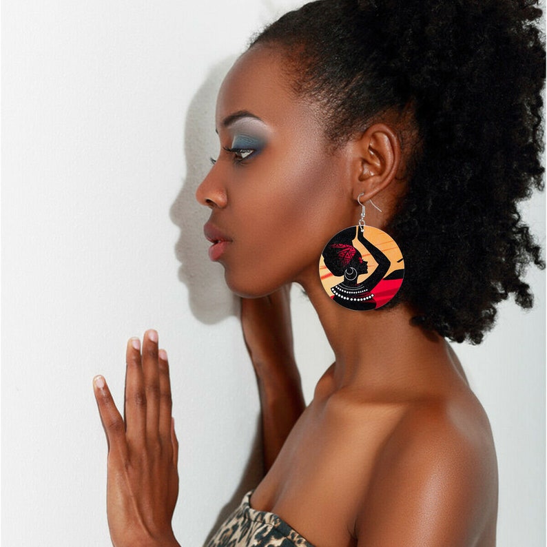 Handcrafted wooden African woman painted earrings by White Baobab featuring traditional African art and intricate design details.