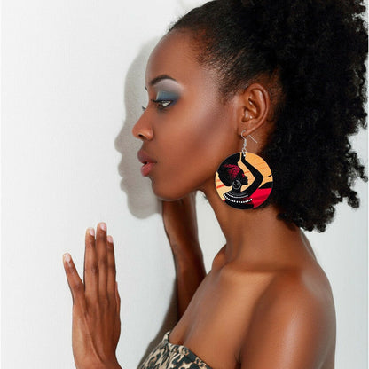 Handcrafted wooden African woman painted earrings by White Baobab featuring traditional African art and intricate design details.