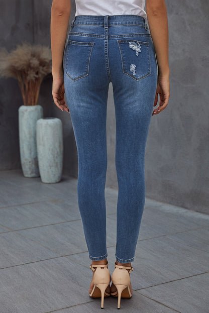 Blue hollow-out vintage skinny ripped jeans by Harlequin Daisy, showcasing distressed denim with a stylish slim fit.