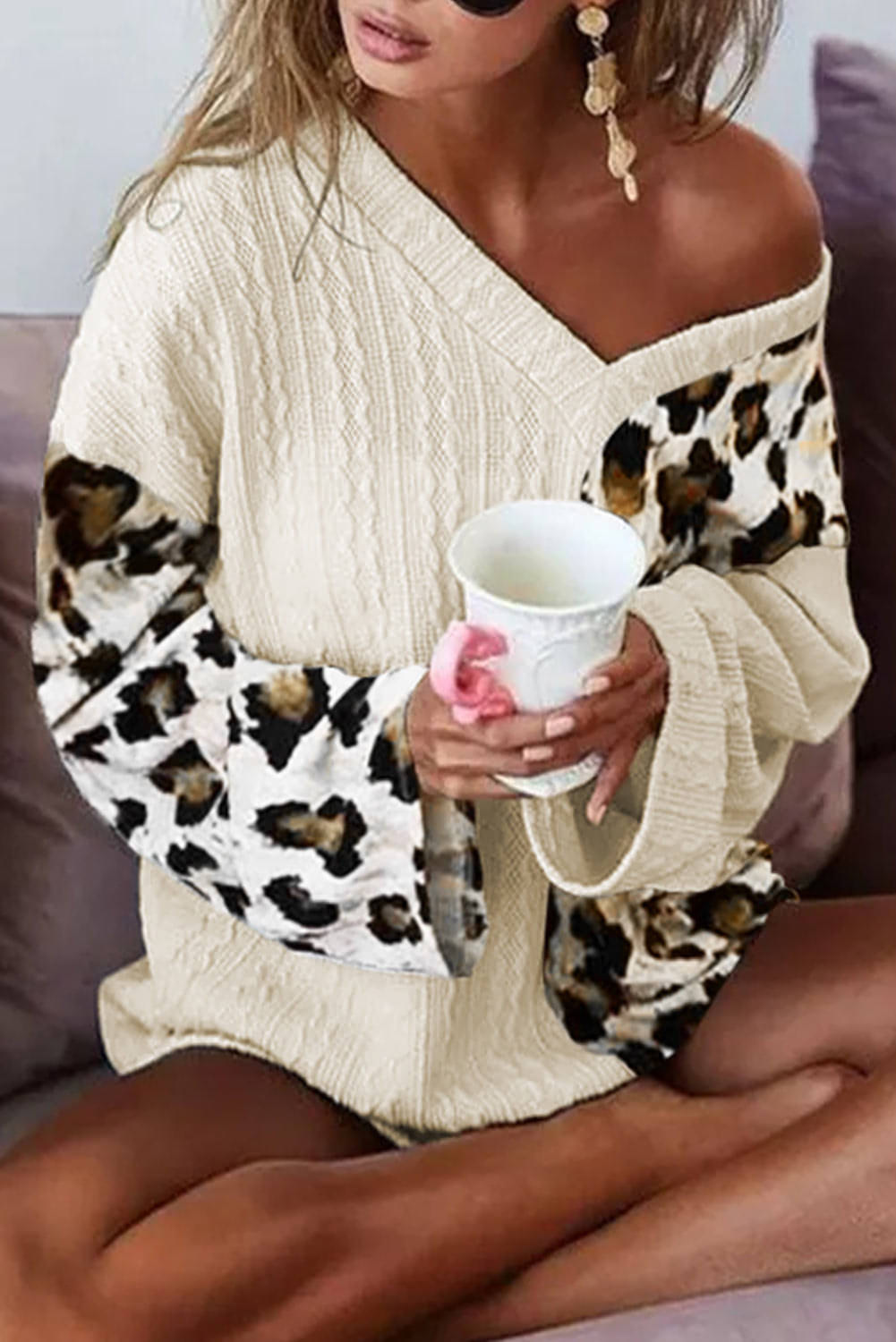 Beige asymmetric leopard patchwork sweater with wide sleeves and V-neck, by Carmine Juneberry, featuring stylish animal print details.