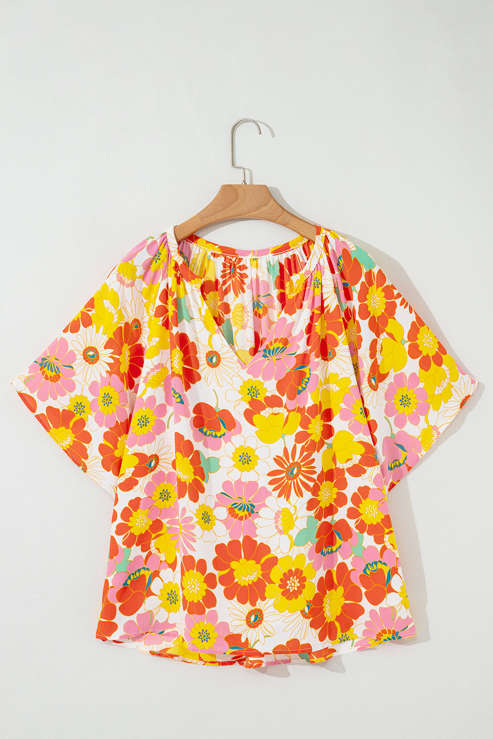 Orange abstract print V-neck blouse with half sleeves from Carmine Juneberry, stylish tops and blouses for casual or work wear.