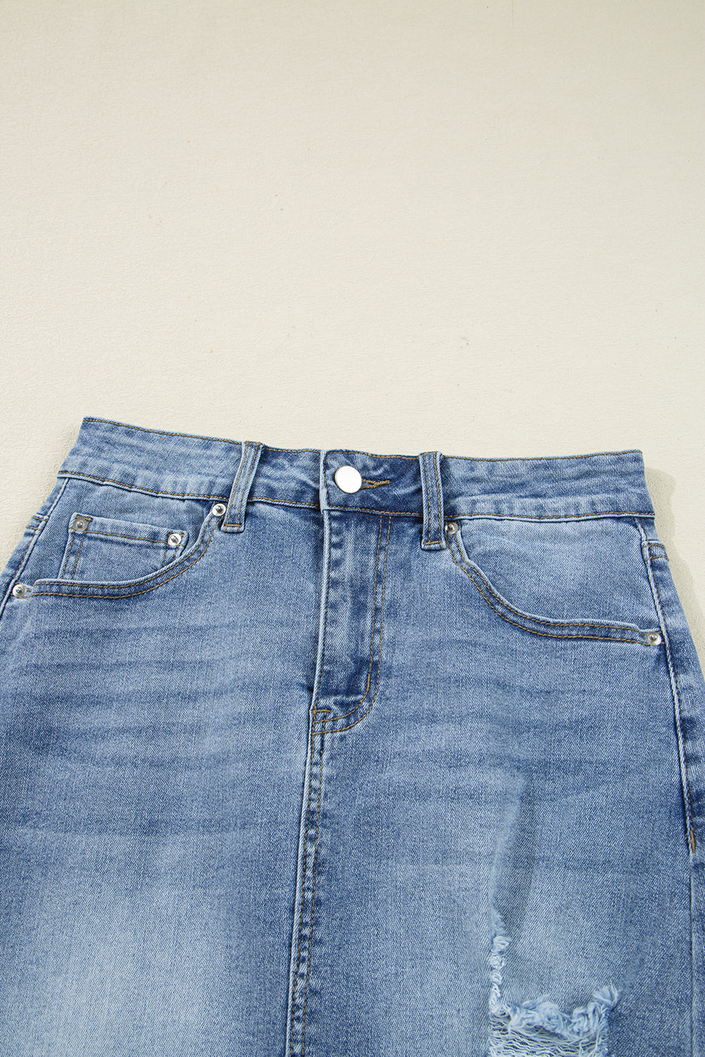 Women’s distressed denim midi skirt by Byzantium Bay featuring a casual fit and frayed hem, styled with pockets and belt loops.