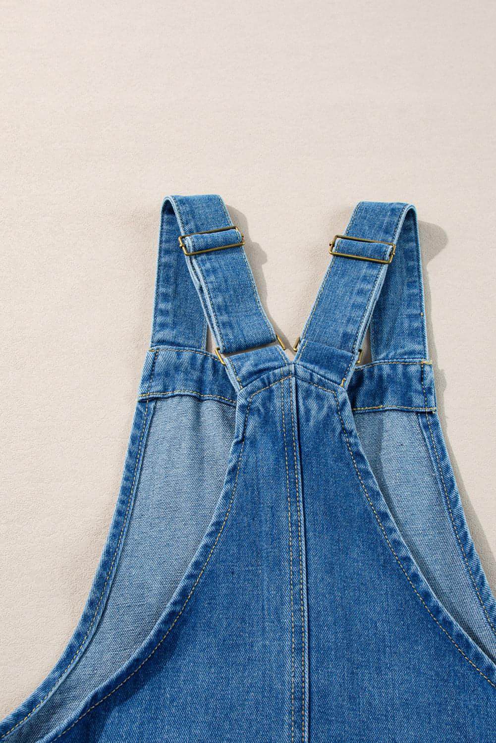 Dusk blue Carmine Juneberry denim mini dress with wide straps, button front and front pockets, casual summer style.