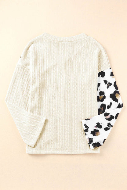 Beige asymmetric leopard patchwork wide sleeve V-neck sweater by Carmine Juneberry, featuring bold animal print and relaxed fit.