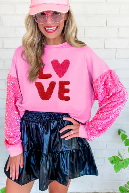 Pink Valentines LOVE Chenille embroidered sequin sleeve sweatshirt by Harlequin Daisy, featuring pink fabric with embroidered love and sequin details.