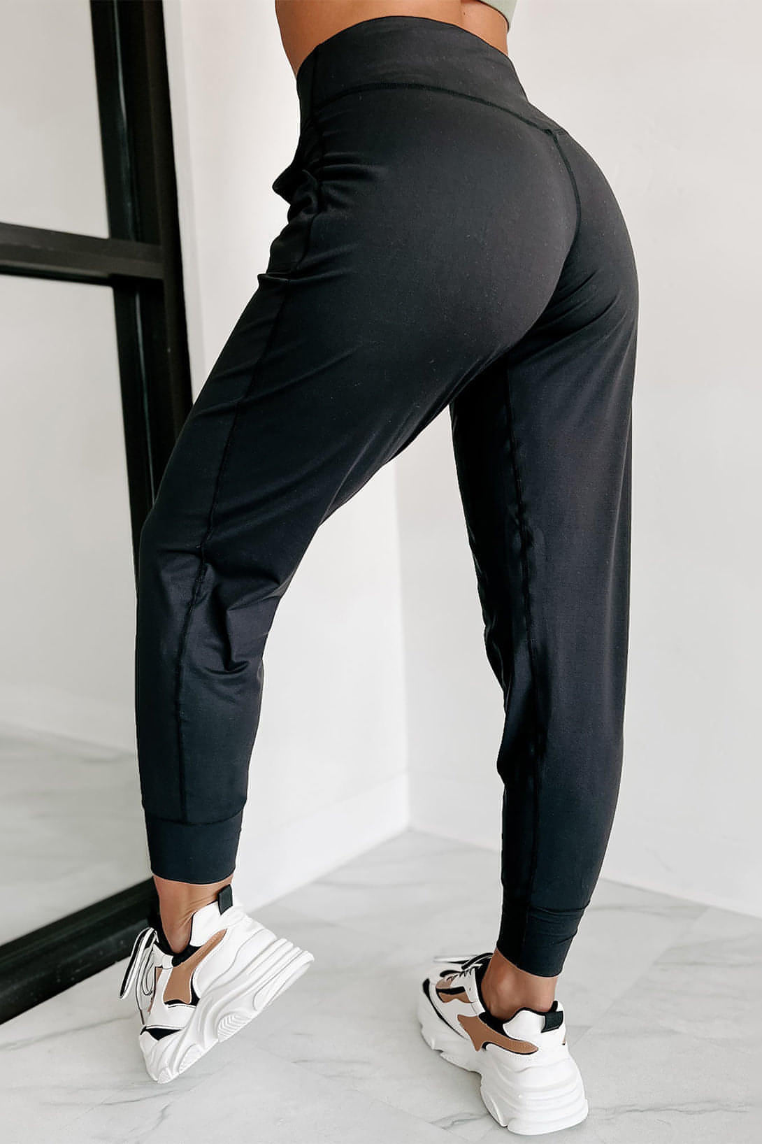 Black exposed seam high waist joggers with pockets from Carmine Juneberry, showcasing their stylish design and comfortable fit.