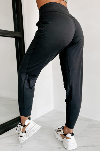 Black exposed seam high waist joggers with pockets from Carmine Juneberry, showcasing their stylish design and comfortable fit.