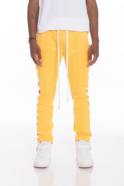 Bright yellow Lime Milo Rasta track pants with bold reggae-inspired patterns and comfortable fit, perfect for casual wear.