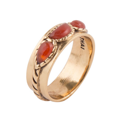 Triple stone orange Carnelian and golden jewelry ring with three round stones set in a gold band.