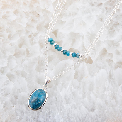 Layered blue apatite and sterling silver necklace with multiple blue gemstone pendants, elegant jewelry piece.