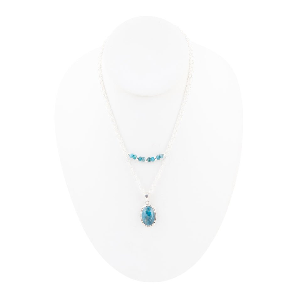 Layered blue apatite and sterling silver necklace featuring multiple blue gemstone beads and silver chain links.