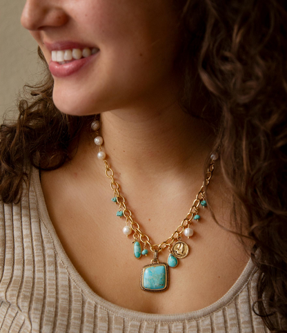 Blue turquoise, white pearl, and gold pendant necklace with multiple charms, stylish jewelry by Start2Finish.