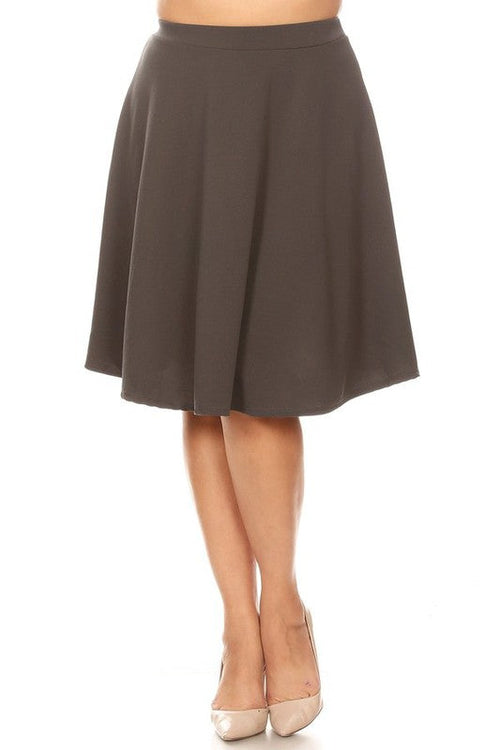 Solid high-waisted A-line knee-length skirt by Jade Icarus, shown in a natural pose highlighting the classic design and fabric.