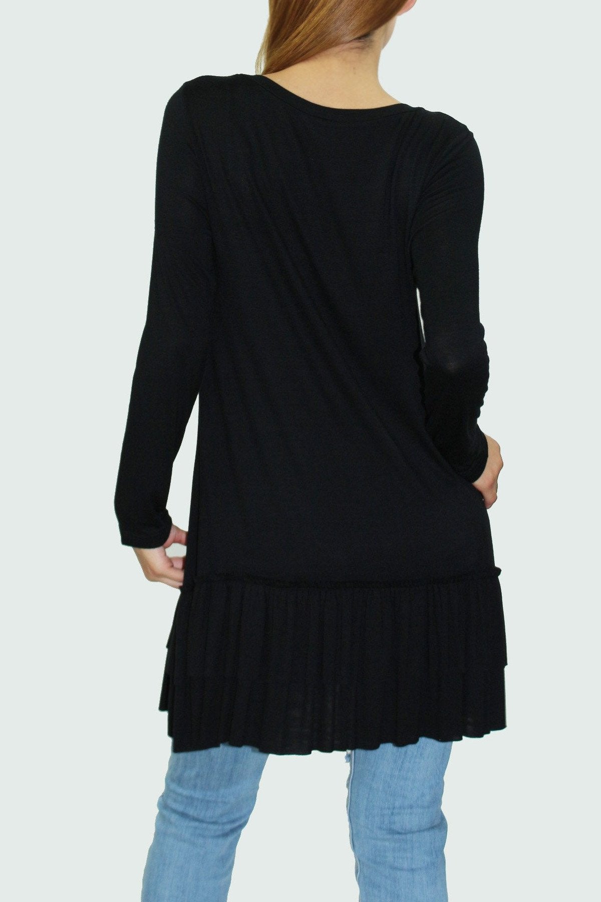 Black ruffle bottom long sleeve tunic by Yellow Hera, showcasing a stylish, flowy blouse with ruffle details at the hem.