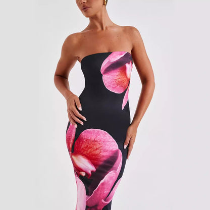 Carmine Juneberry 25 Edition backless floral draped tube maxi dress displayed on a model, featuring vibrant floral patterns and a flowing silhouette.