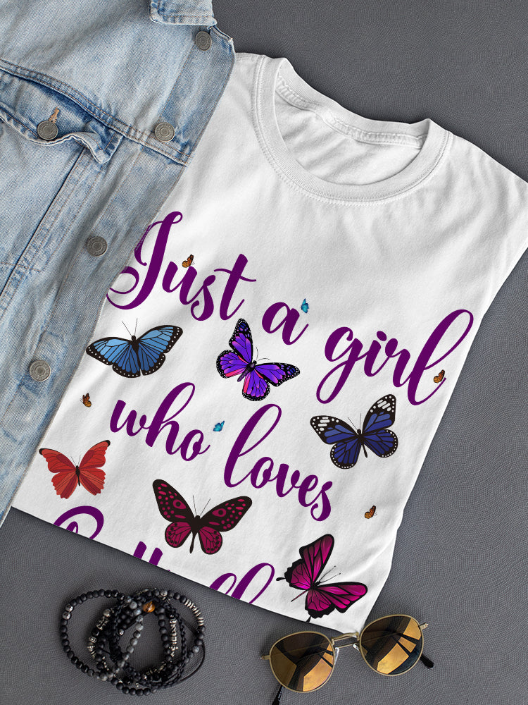 A girl wearing a colorful butterfly graphic T-shirt by Start2Finish, featuring vibrant butterfly illustrations on the apparel.