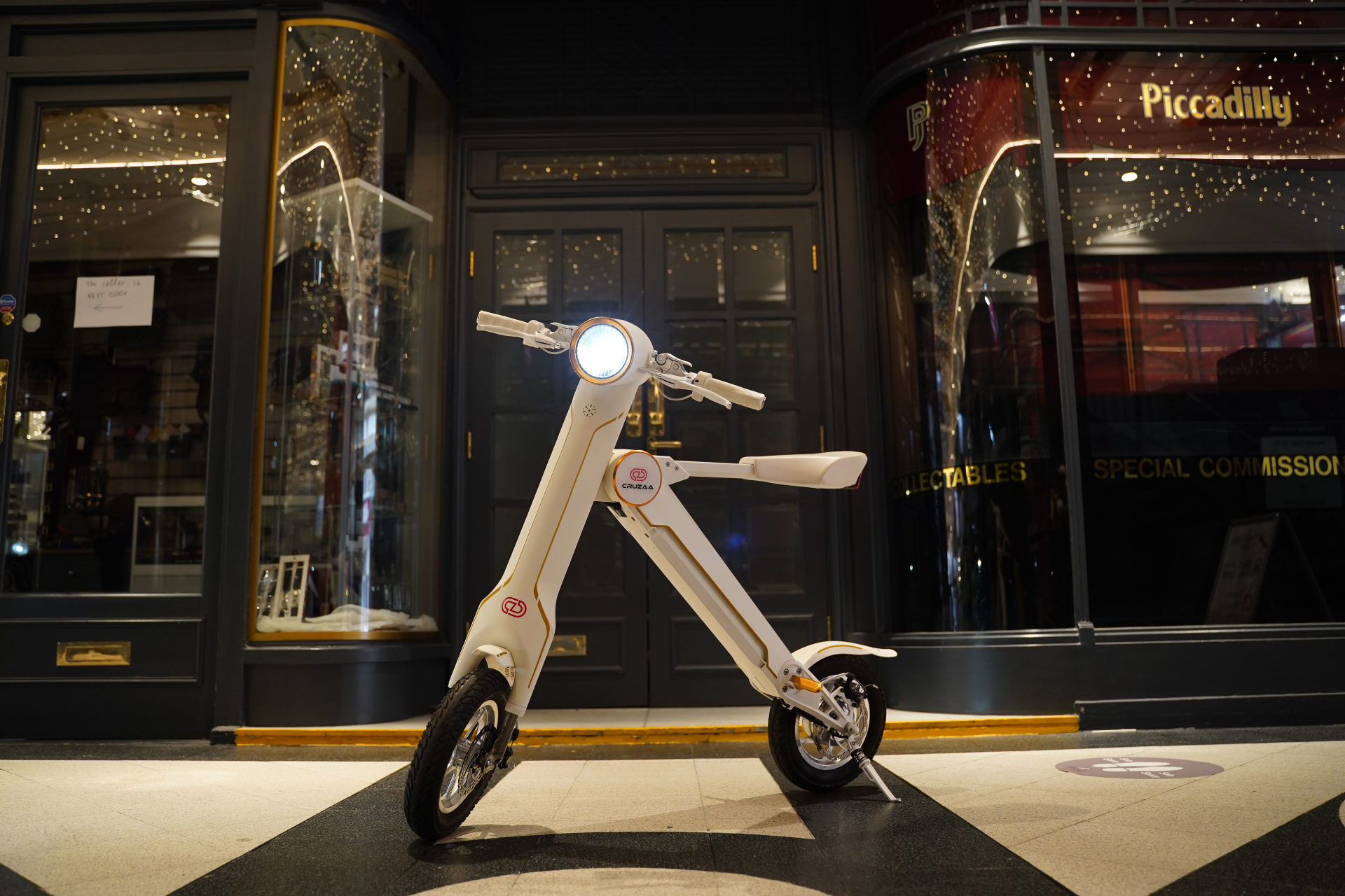 Start2Finish Cruzaa PRO electric scooter in racing white with built-in Bluetooth, speakers, USB port, showing handlebars and deck.