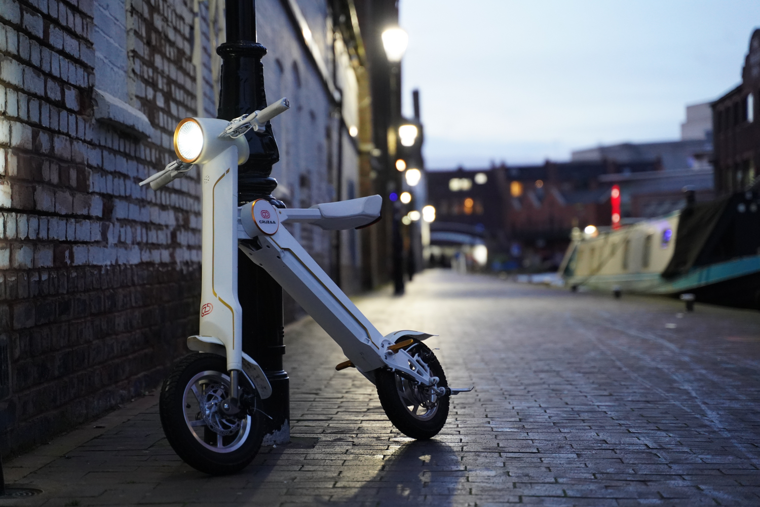 Start2Finish Cruzaa PRO electric scooter in racing white with Bluetooth speakers, USB port, large wheels, and sleek design.