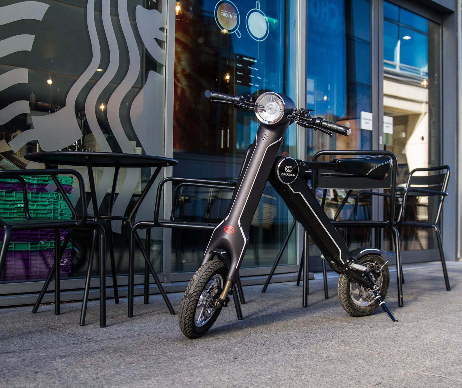 Start2Finish Cruzaa electric scooter with Bluetooth speakers, USB port, 25km/h top speed, and 35km range, shown on a city street.