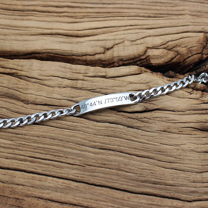 Personalized steel chain bracelet from Fuchsia Molly with adjustable links and engraved charm, displayed on a neutral background.