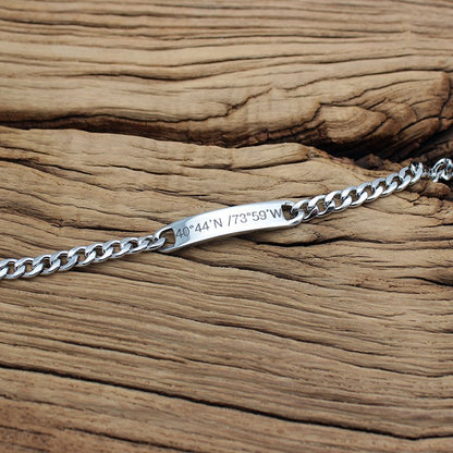 Personalized steel chain bracelet from Fuchsia Molly with adjustable links and engraved charm, displayed on a neutral background.