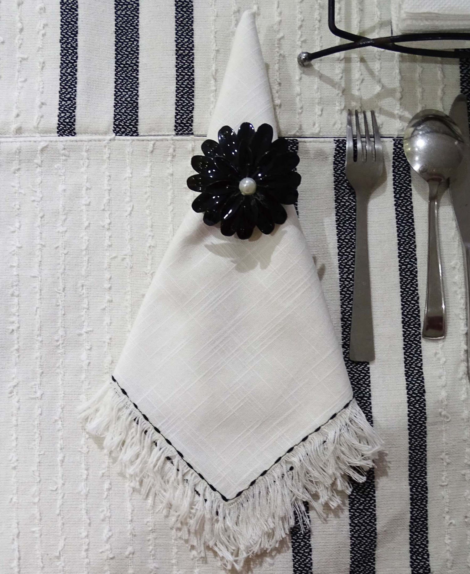 Set of four Start2Finish home table cloth napkins with elegant black embroidery showcasing intricate detailing.