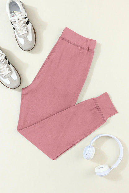 Carmine Juneberry fuchsia joggers with drawstring waist and side pockets, designed for activewear and comfortable movement.