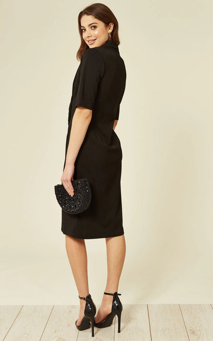 Black Diane Wrap Blazer Dress by Rose Eleusis, featuring a tailored fit, lapel collar, and waist tie, styled as a versatile jacket and dress.