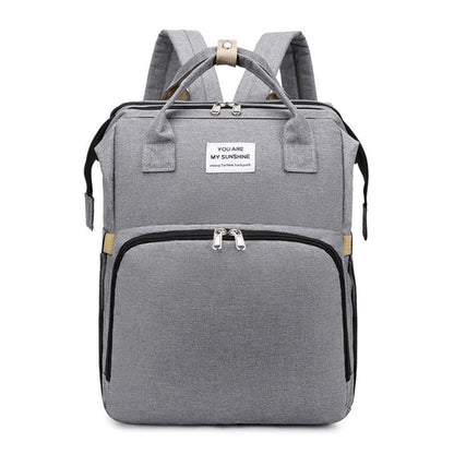 Carmine Juneberry ALLFASHION™ FoldAway BabyNest Backpack with adjustable straps and compact foldable design, shown open and packed.