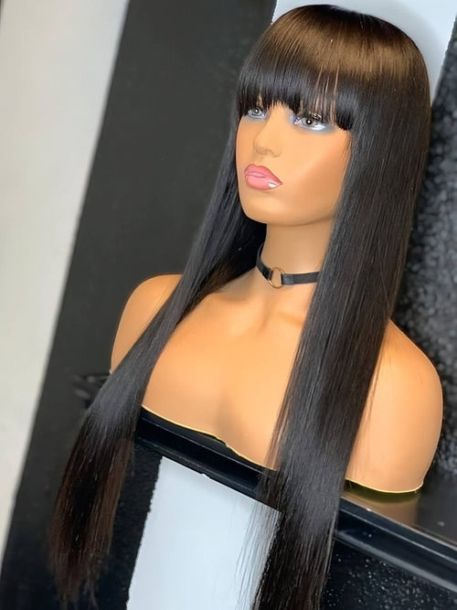 Carmine Juneberry LuxeWaves Brazilian straight black 30-inch 100% real hair wig with long bangs, styled for a natural look.