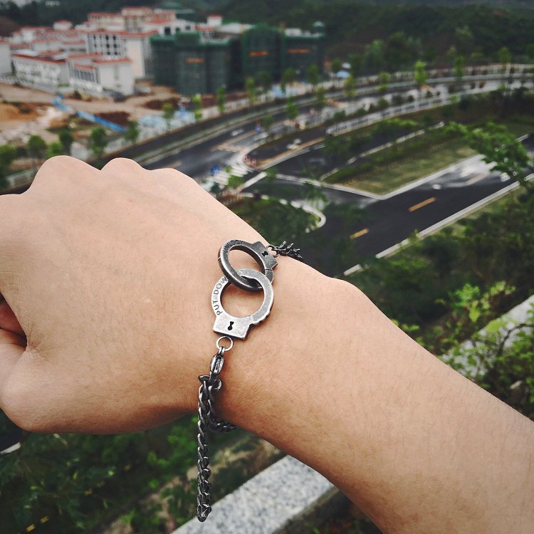 Fuchsia Molly handcuffs bracelet with metallic chain design, stylish accessory for edgy fashion looks.