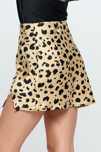 Leopard print satin mini skirt with slit from Jade Icarus, shown on a model with a stylish, bold fashion look.