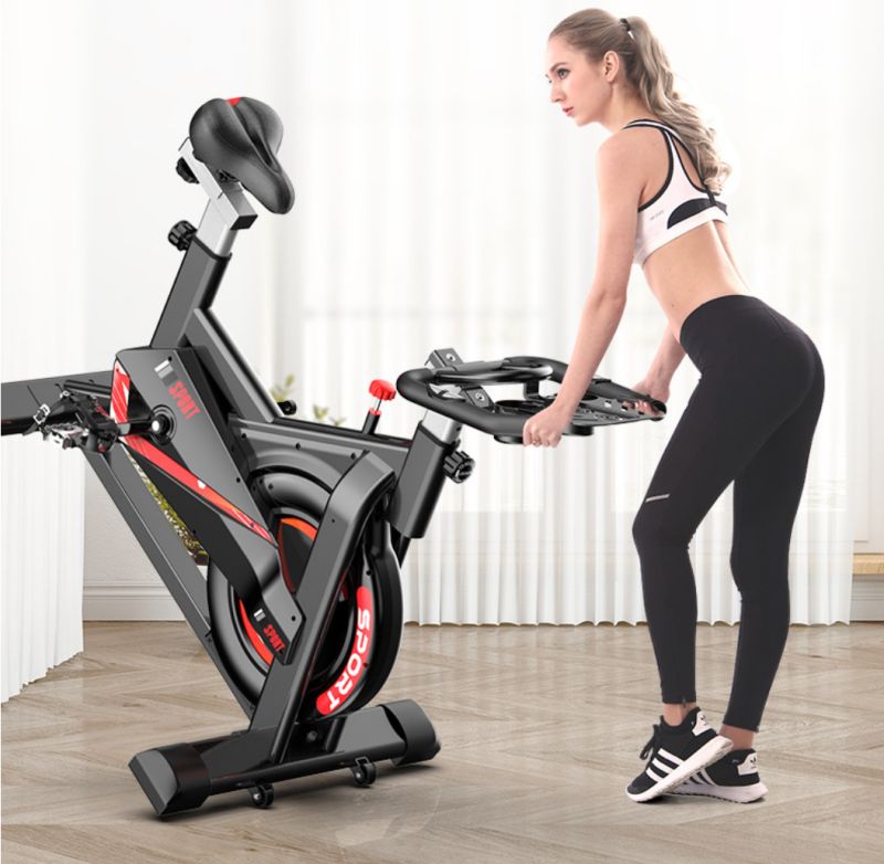 Indoor spinning bike by Puce Orpheus with monitor displaying heart rate data, used for cardio workouts and fitness training.