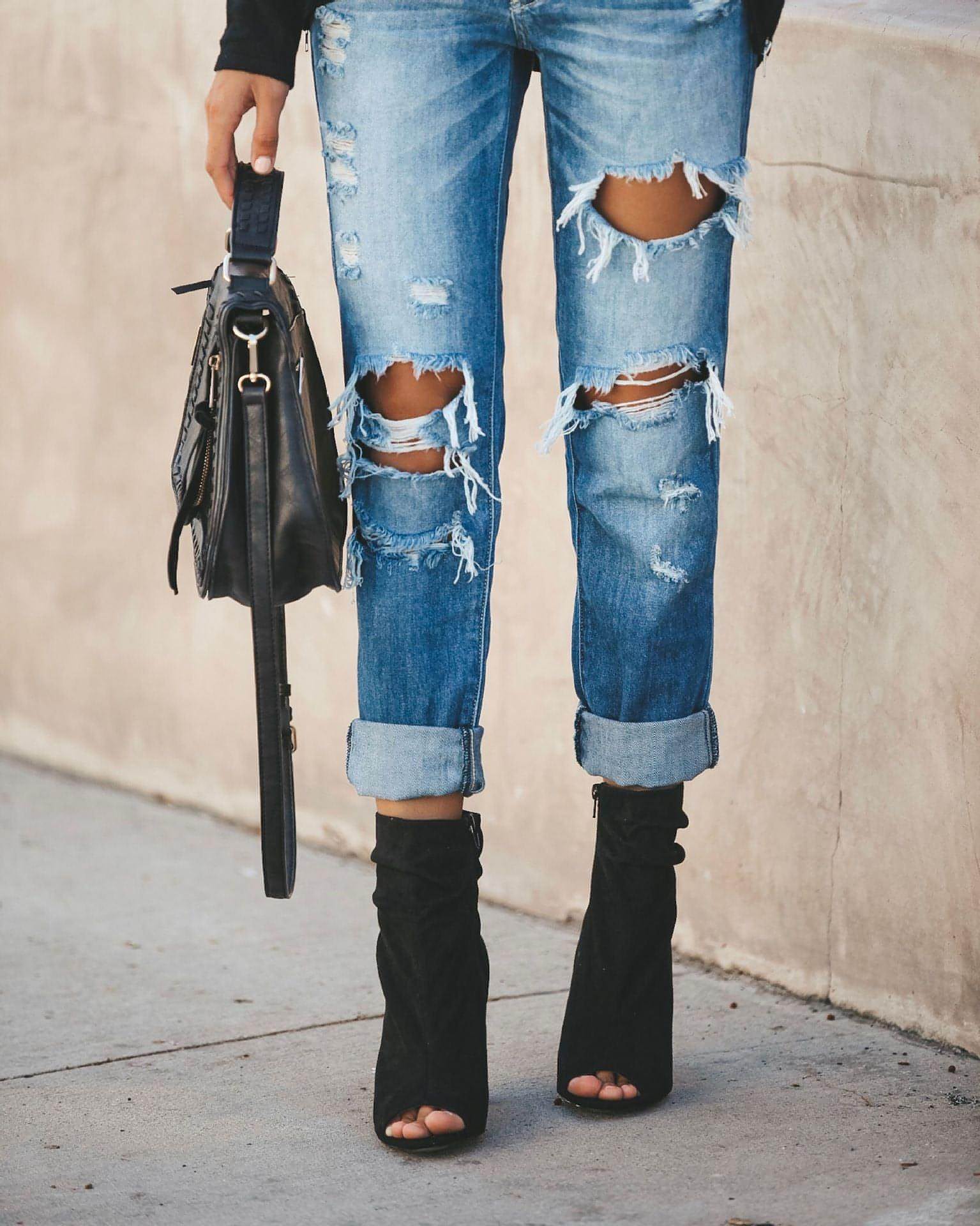 Carmine Juneberry large ripped jeans showing distressed denim with torn knees and frayed edges on a casual style pair.