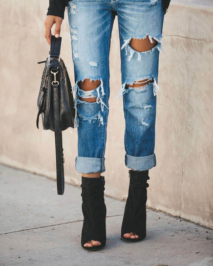 Carmine Juneberry large ripped jeans showing distressed denim with torn knees and frayed edges on a casual style pair.
