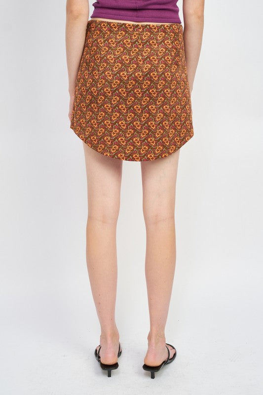 Printed mini skirt with curved hem by Jade Icarus, showing the stylish design and vibrant pattern on the women&