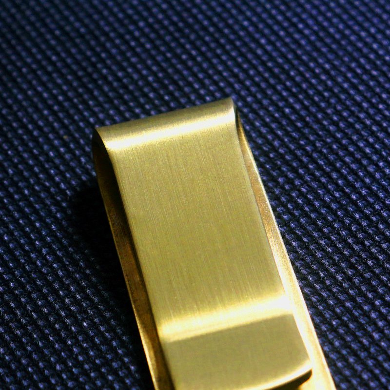 Brass money clip from Fuchsia Molly, stylish home decor accessory with a sleek, polished finish and minimalist design.