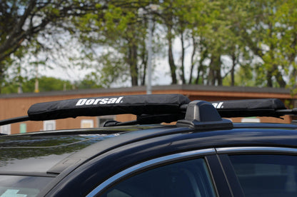 Cyan Hecuba DORSAL Aero Rack Pads on 34-inch car crossbar for roof surfboard, kayak, and SUP transportation.